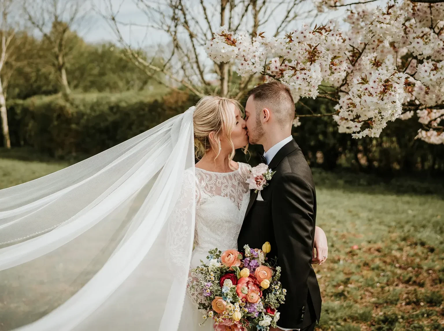 Couple kissing at Clock Barn spring wedding